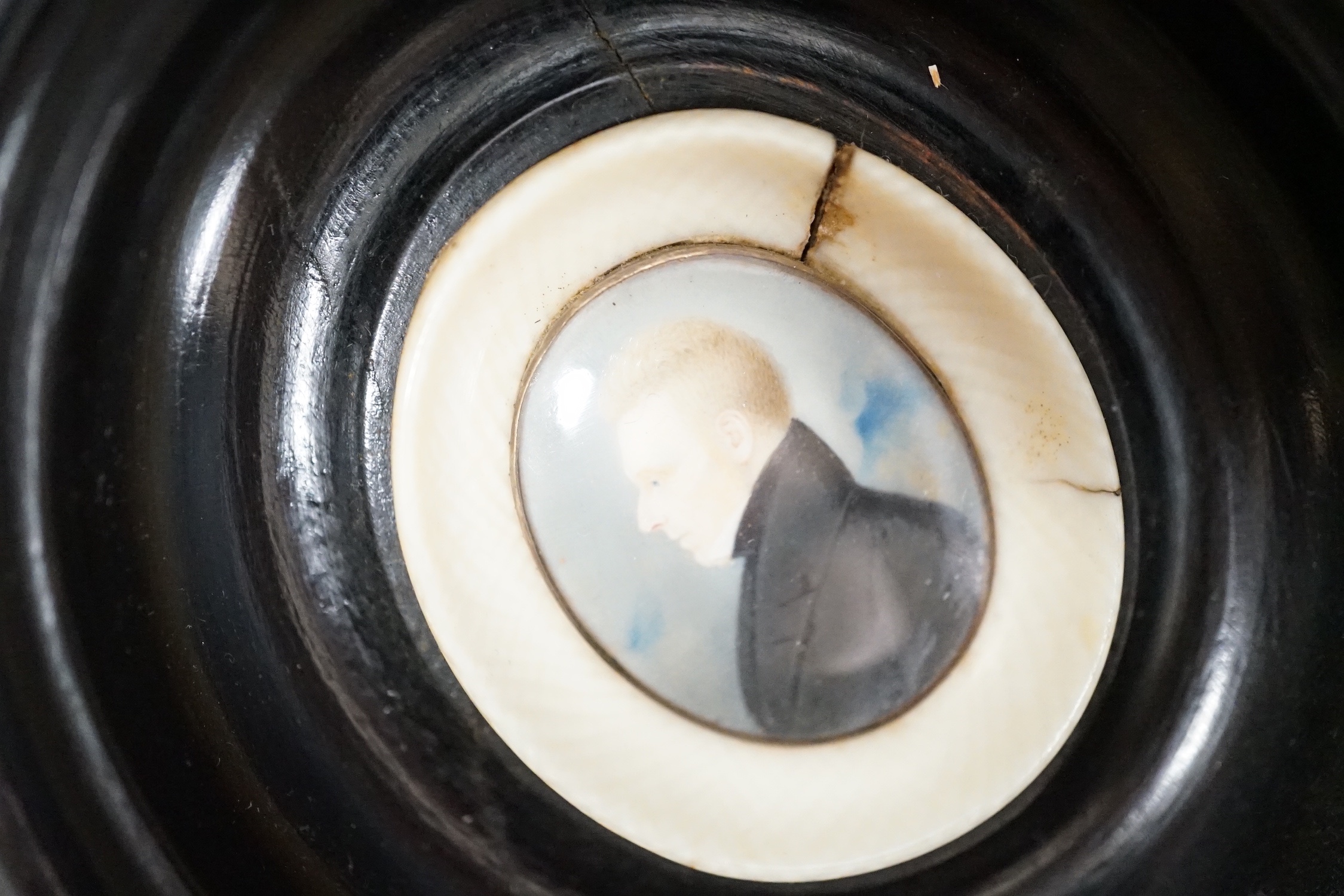 A 19th century portrait miniature on ivory of a gentleman in oval frame, 9.5cm and an overpainted photographic portrait (2)